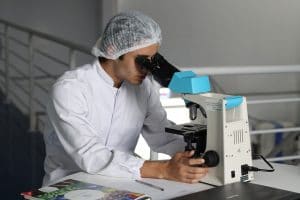 Chemiker führt Wasseranalyse und Legionellenprüfung mit dem Mikroskop im Labor durch